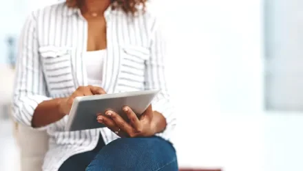 Woman in a striped shirt looking at a tablet screen